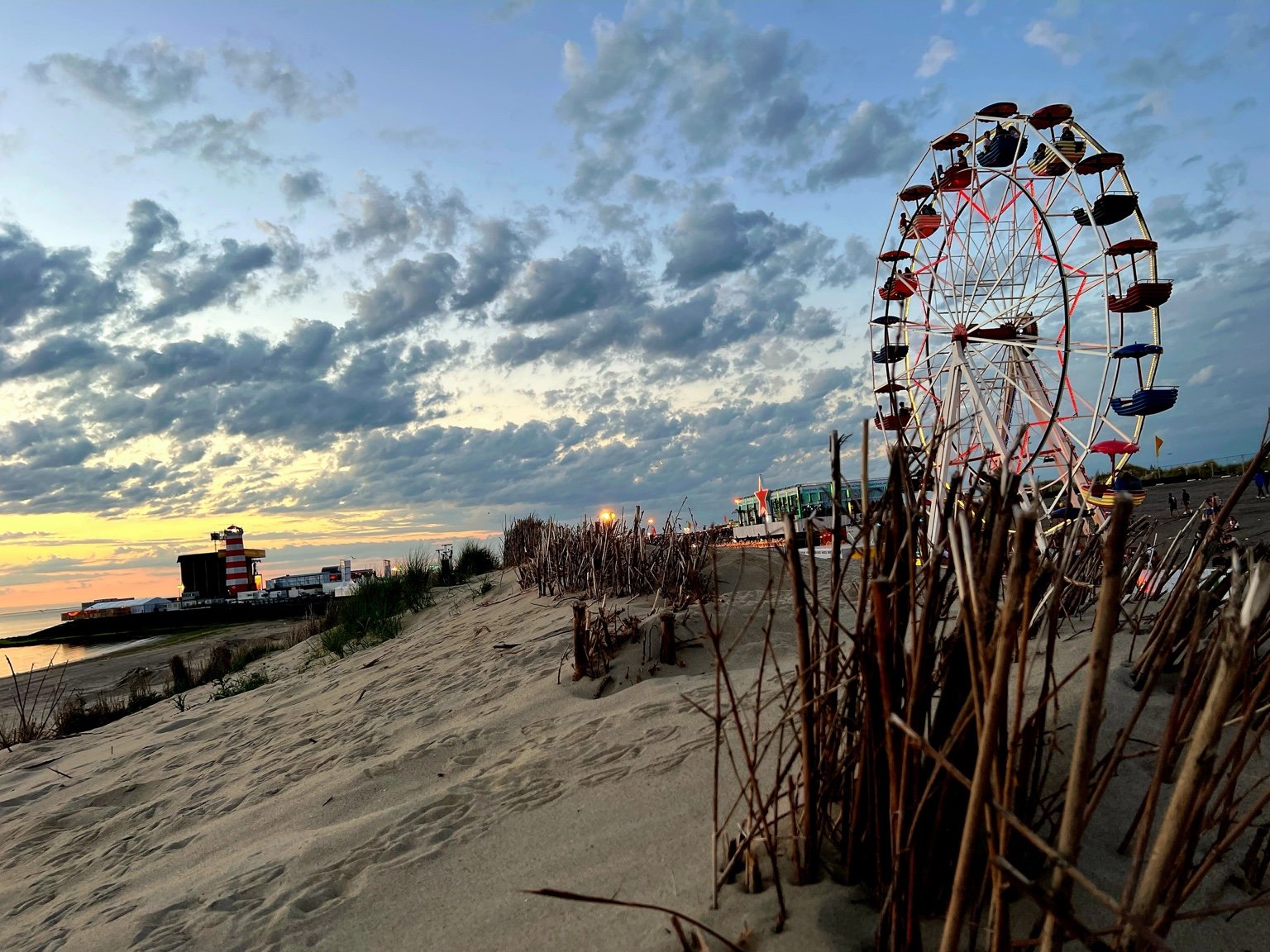 Reuzenrad op strand bij zonsondergang